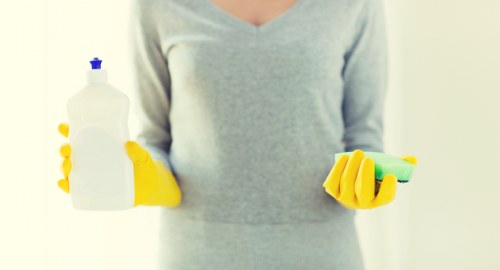 A professional cleaner maintaining a Mayfair residential property with careful dusting and floor care